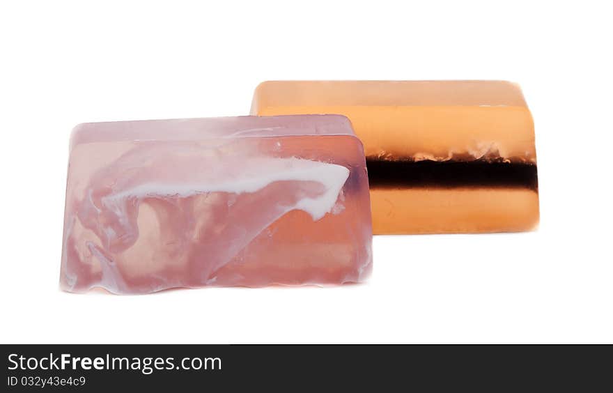 Two pieces of fruit soap on white background