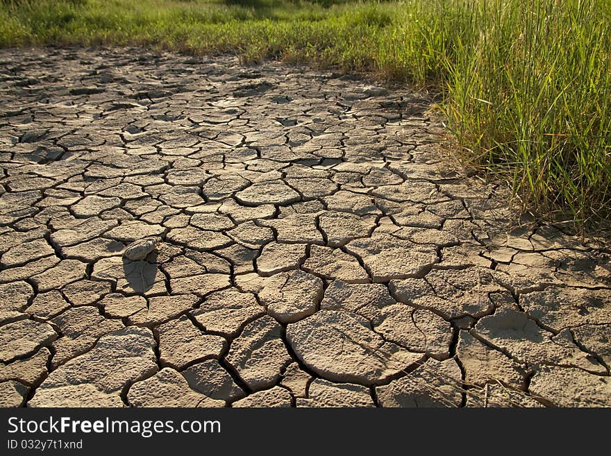 Cracked by the heat long lifeless soil. Cracked by the heat long lifeless soil