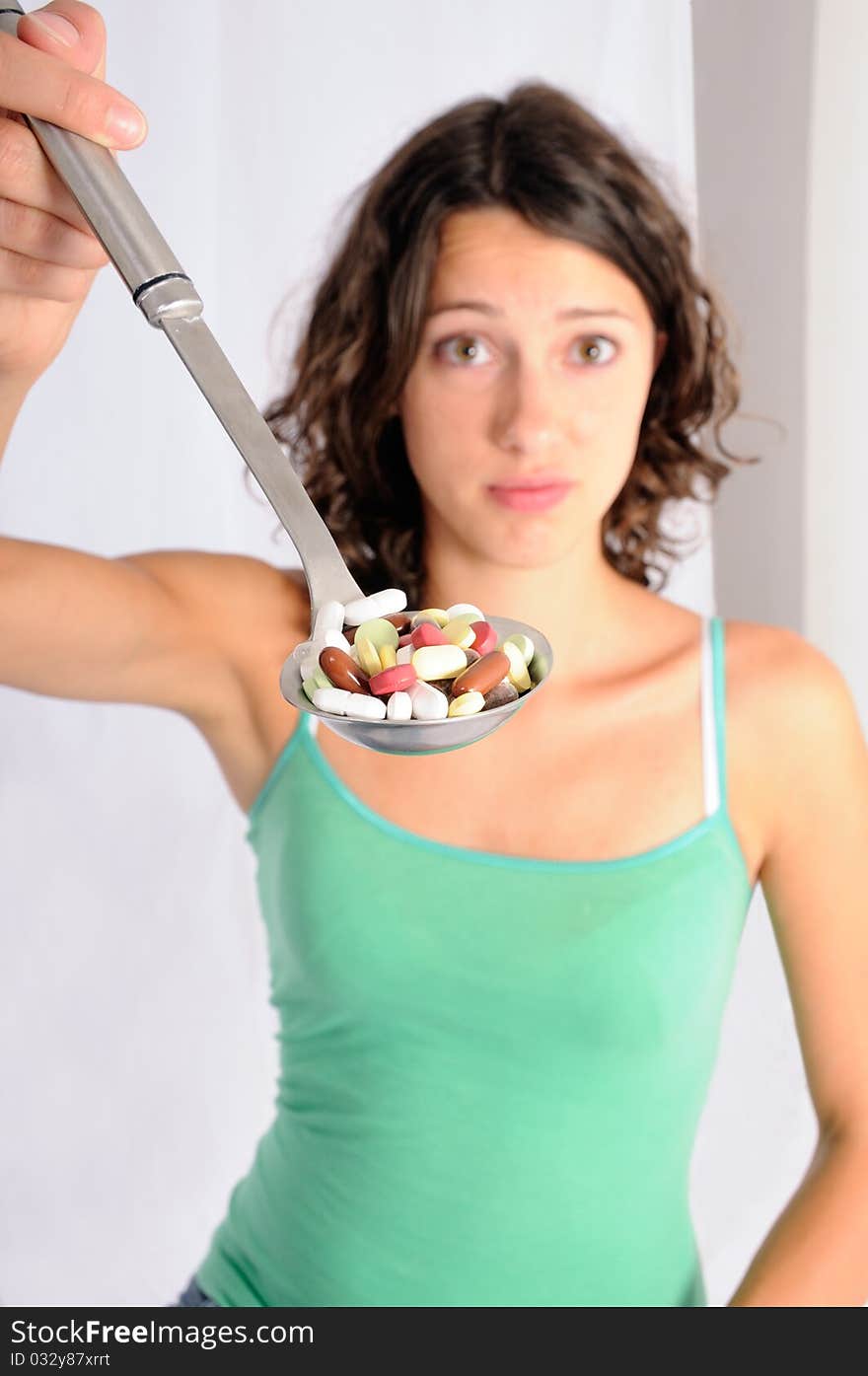 Shot of cute girl with spoon full of pills. Concept shot for alternative medicine. Shot of cute girl with spoon full of pills. Concept shot for alternative medicine