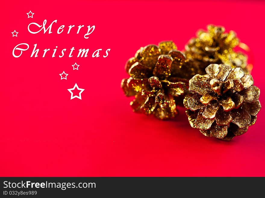 Golden cones on red background;christmas decoration. Golden cones on red background;christmas decoration