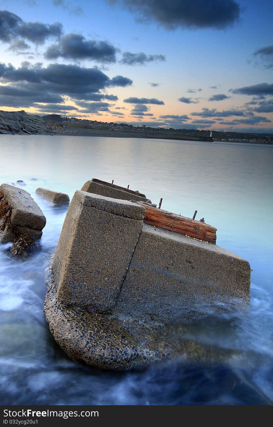 The remnants of an old railway lay abandoned in the sea, the structures are being eroded and reclaimed by nature. The remnants of an old railway lay abandoned in the sea, the structures are being eroded and reclaimed by nature.