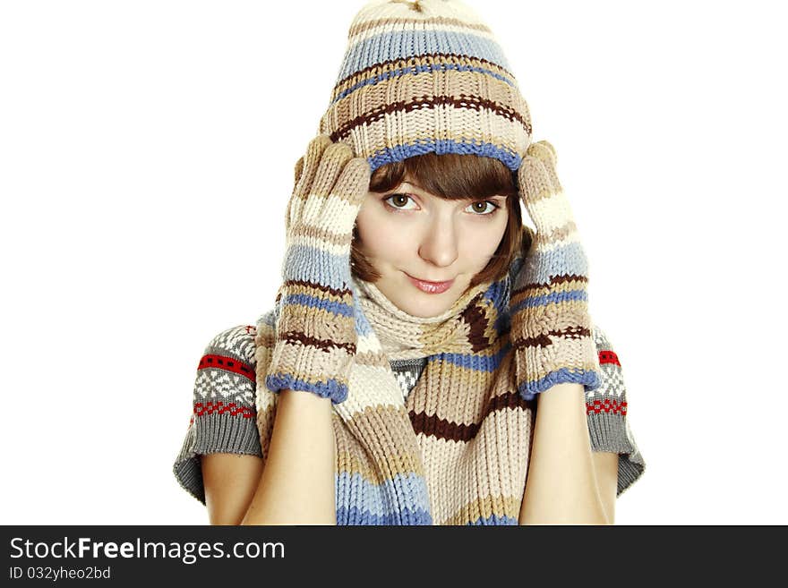 Photo of a young woman in soft sweater, cap and mittens, holding her head between her hands. Isolated on a white background. Photo of a young woman in soft sweater, cap and mittens, holding her head between her hands. Isolated on a white background