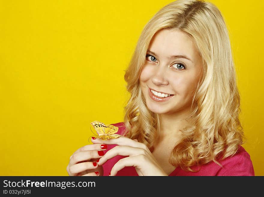 Portrait of a beautiful young woman with a butterfly on a yellow background. Isolated on a white background. Portrait of a beautiful young woman with a butterfly on a yellow background. Isolated on a white background