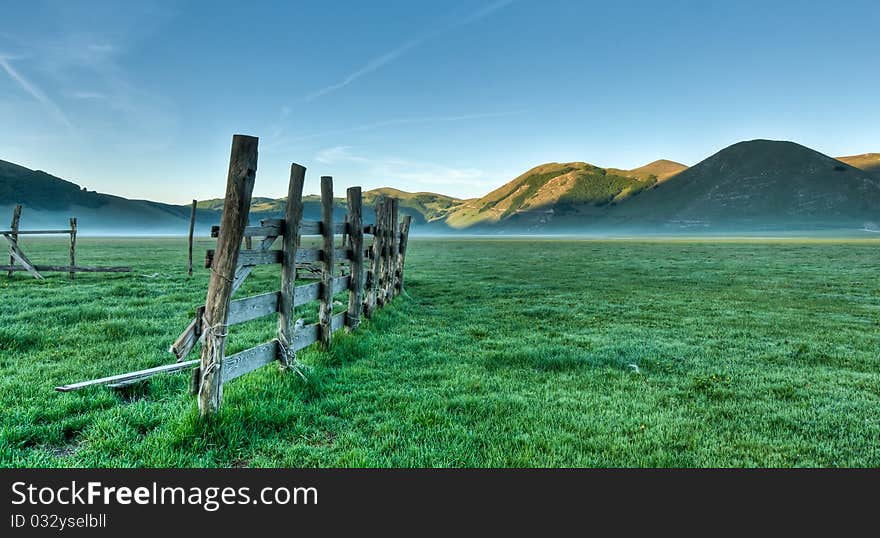 Old fence in mountain plain, Piano Grande, Italy, in early morning. Old fence in mountain plain, Piano Grande, Italy, in early morning