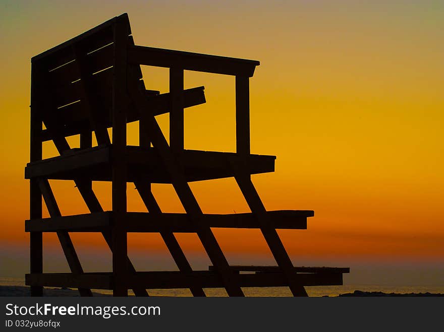 Lifeguard chair silhouette at dawn