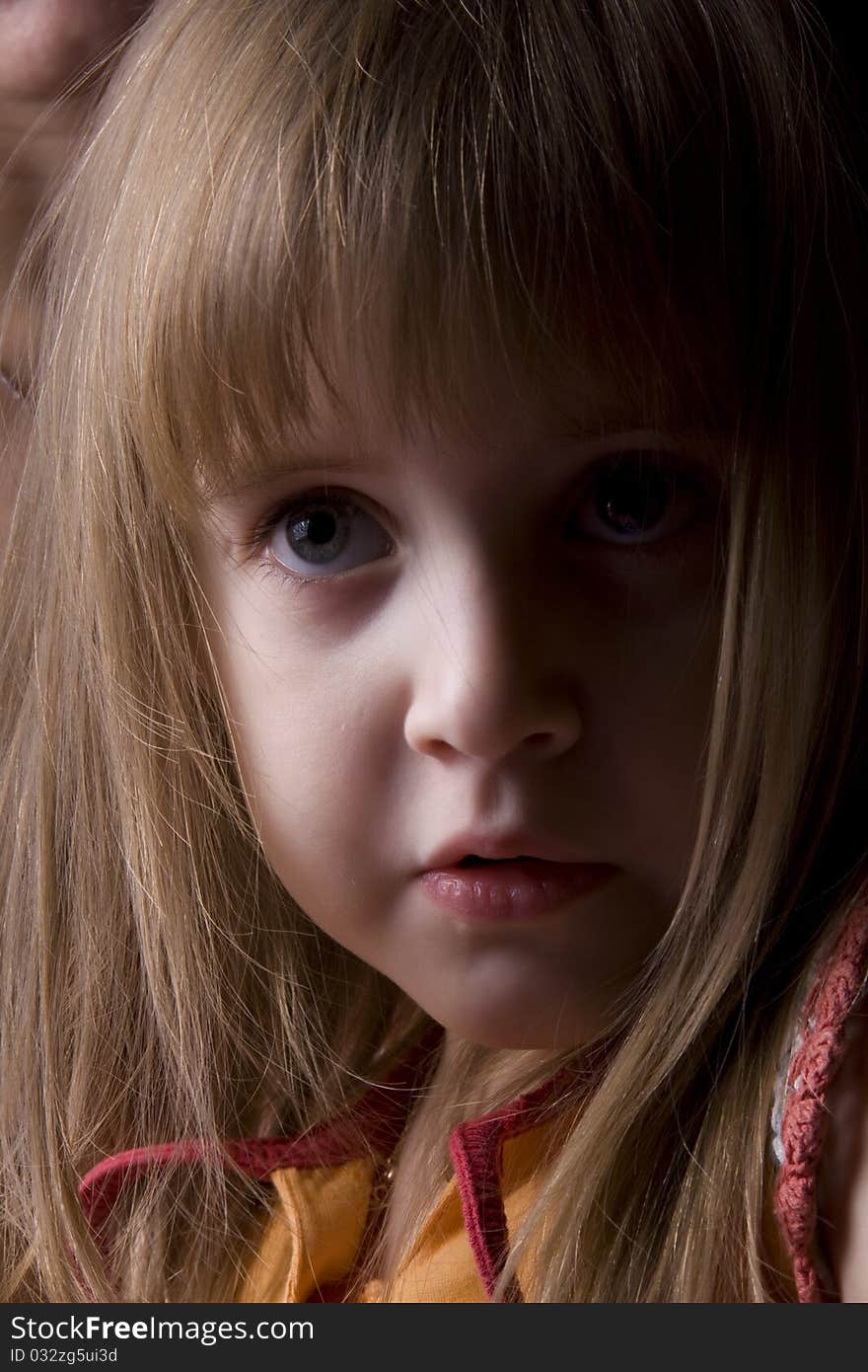 The little girl attentively looks. The little girl attentively looks