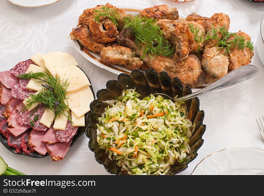 Fried fish and cabbage salad on a dining table. Fried fish and cabbage salad on a dining table.