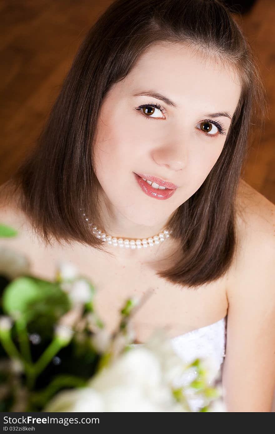 Studio portrait of beautiful stylish bride with flowers