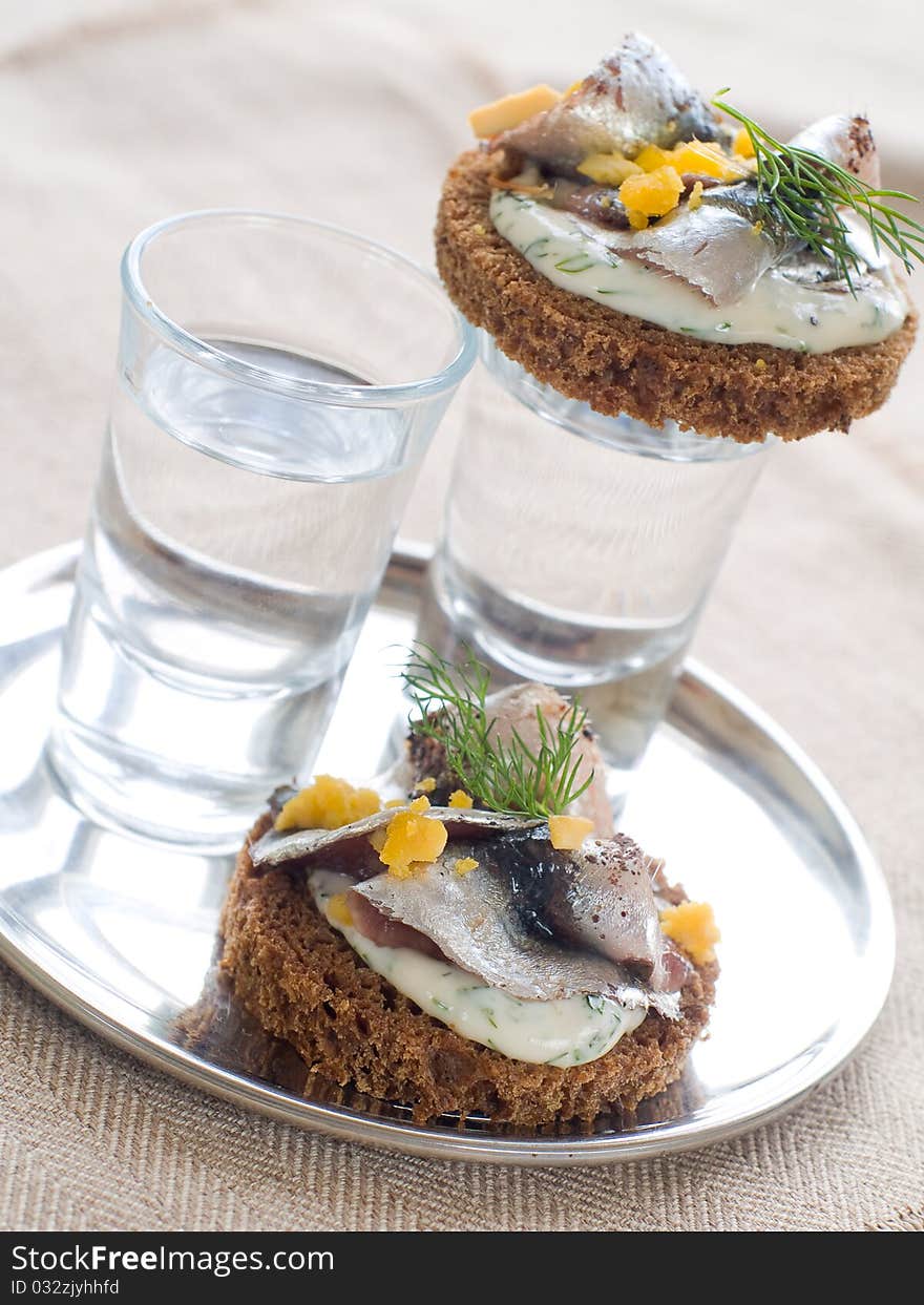 Anchovy canapes garnished with dill and yolk and vodka. Anchovy canapes garnished with dill and yolk and vodka