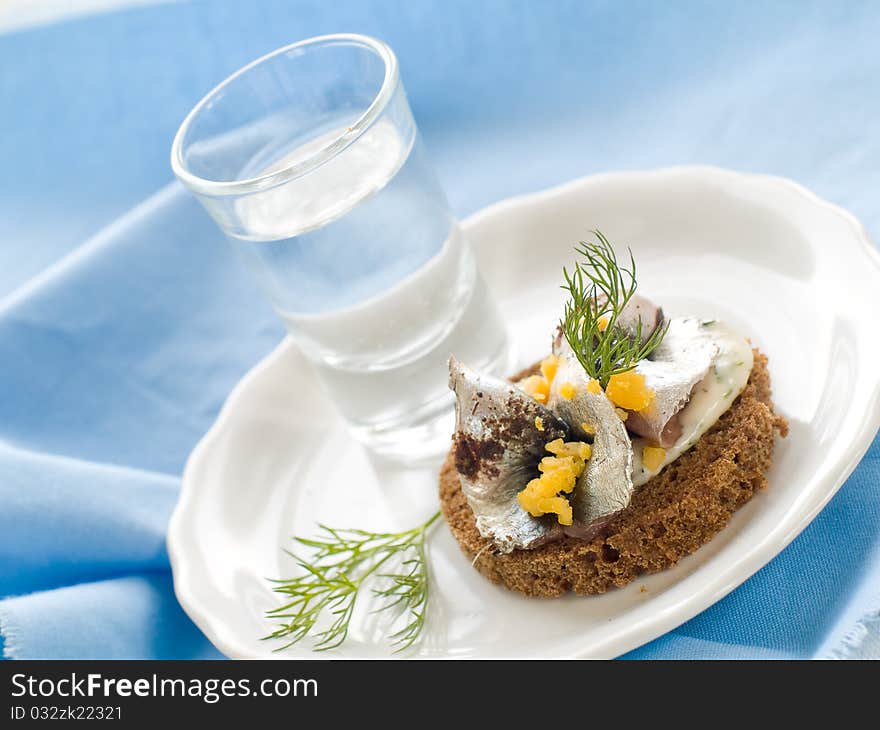 Anchovy canapes garnished with dill and yolk and vodka. Anchovy canapes garnished with dill and yolk and vodka