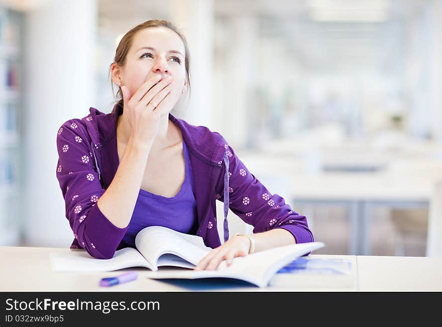 Pretty young college student in a library