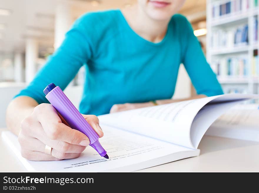 Pretty young college student in a library