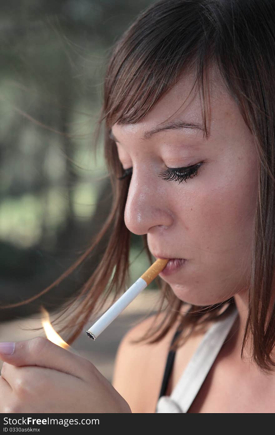 Portrait of  young woman lighting a cigarette