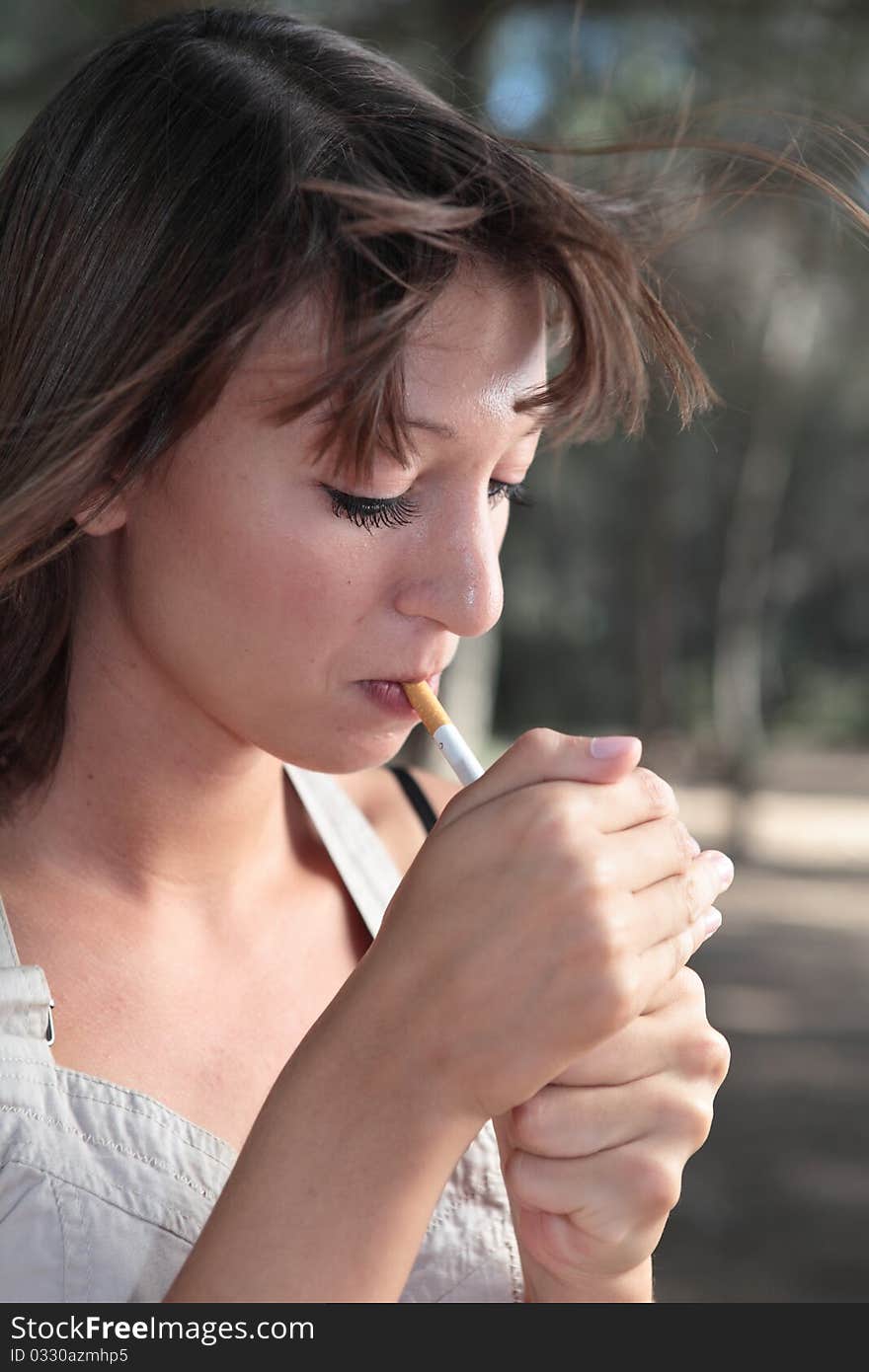 Portrait of  young woman lighting a cigarette