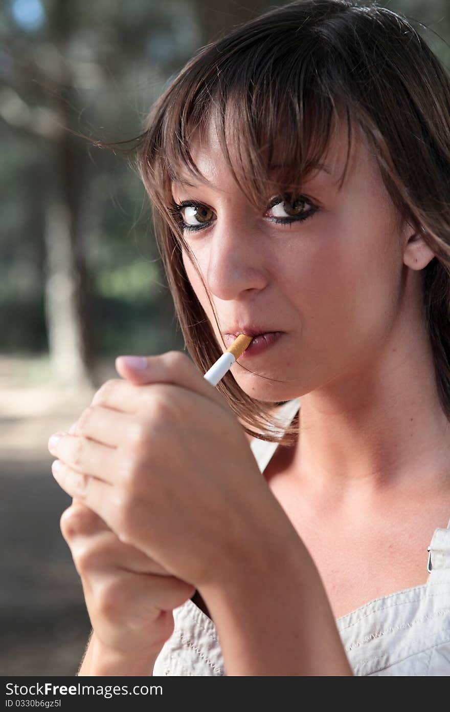 Portrait of  young woman lighting a cigarette