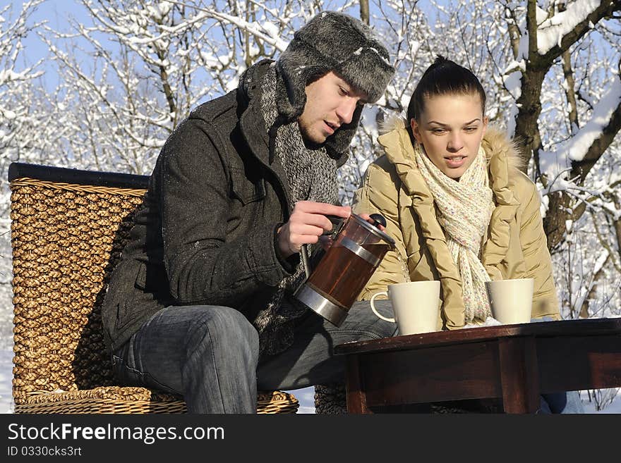 Teenager boy preparing hot tea for his girl friend in winter season. Teenager boy preparing hot tea for his girl friend in winter season