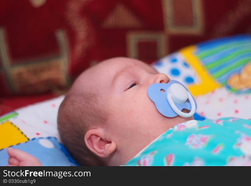 Photo of the beautiful baby lying on bed. Photo of the beautiful baby lying on bed