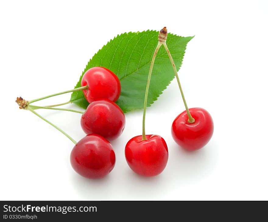 Cherry with a green leaf on white background.