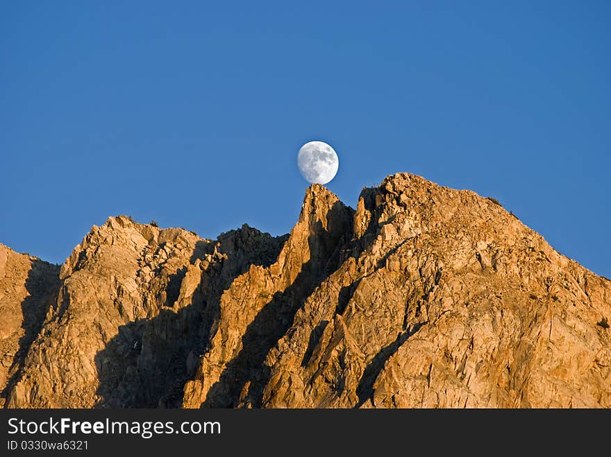 Moon balanced on a mountain peak. Moon balanced on a mountain peak.