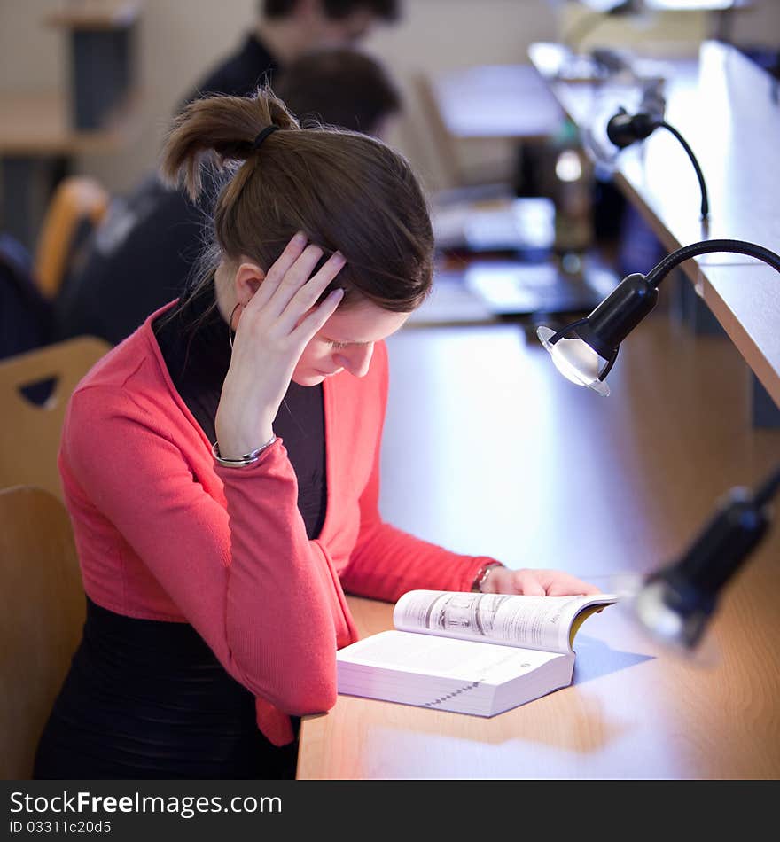 Pretty female college student in a library