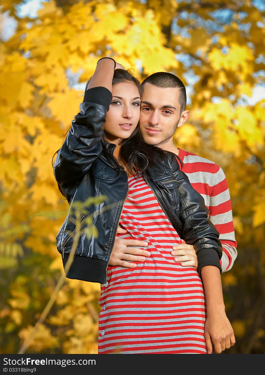 Couple of young lovers are walking in the autumn park. Couple of young lovers are walking in the autumn park