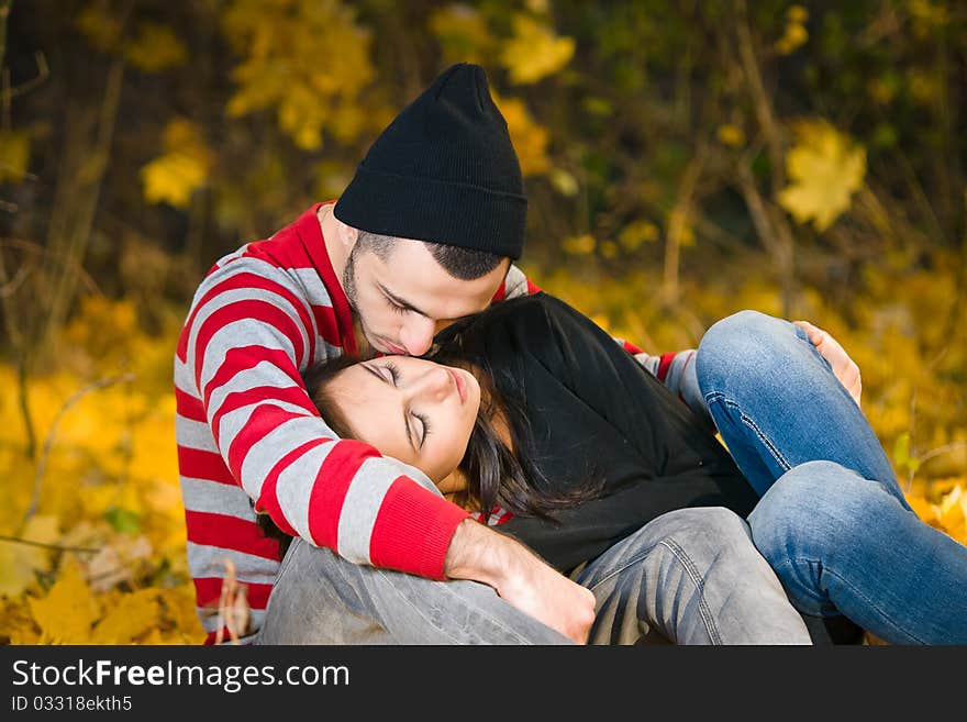 Couple of young lovers are walking in the autumn park. Couple of young lovers are walking in the autumn park