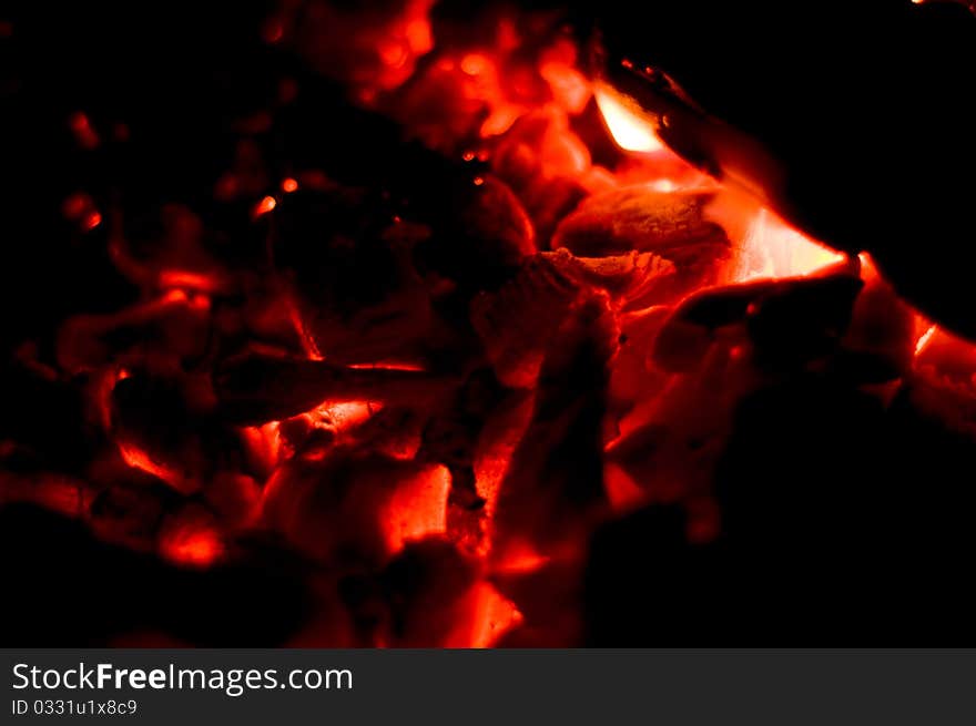 Coals flicker on a burning down fire