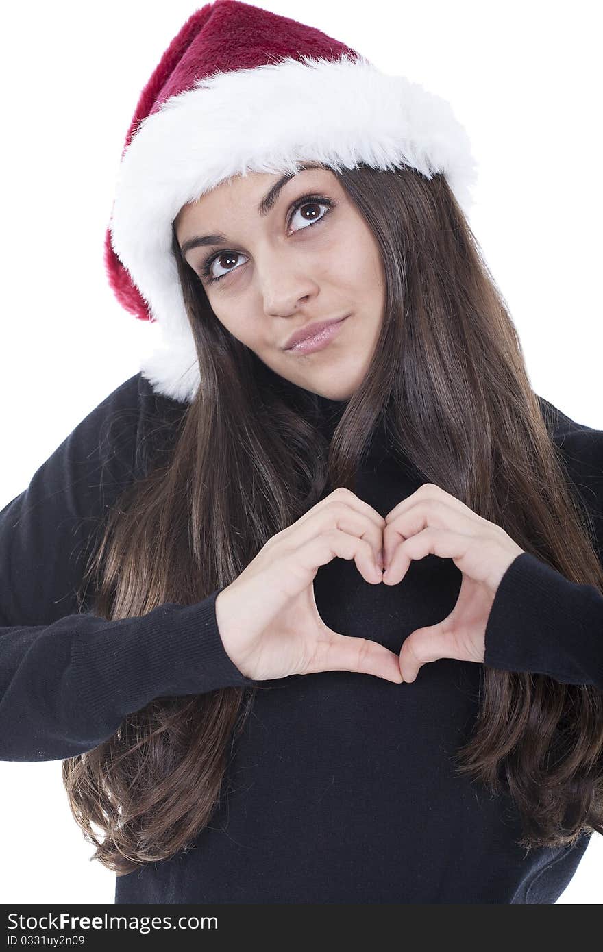 Form of heart shaped by the hands of a young woman with christmas hat