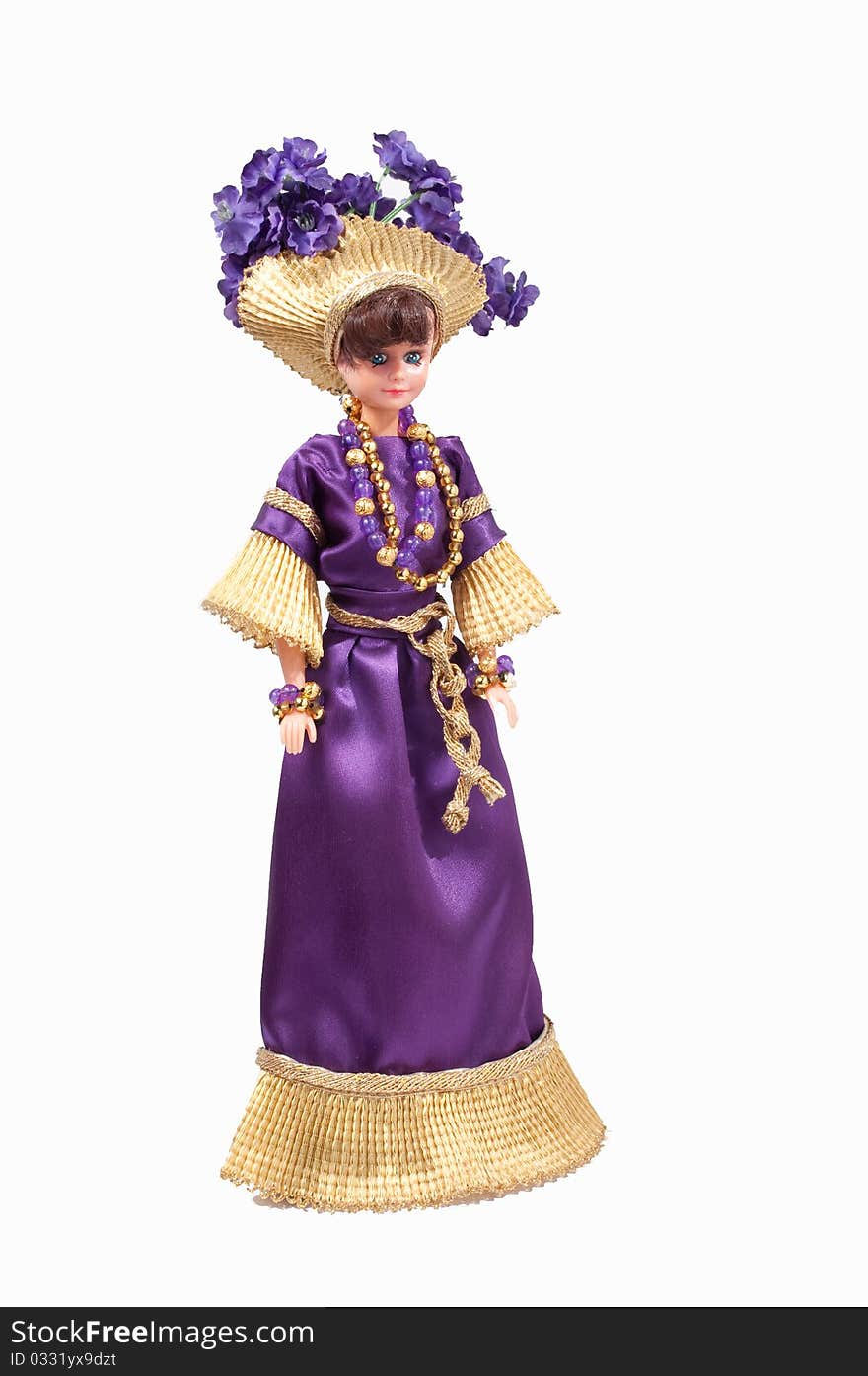 Girl's doll wearing handmade dress and hat. She wears a purple dress with gold trim and a gold hat with purple flowers. Girl's doll wearing handmade dress and hat. She wears a purple dress with gold trim and a gold hat with purple flowers.