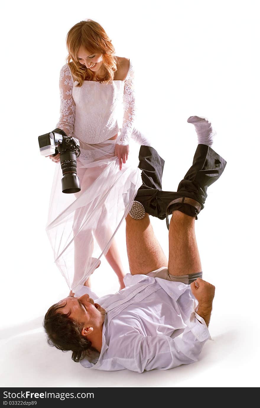 Bride taking picture of her groom laying on floor