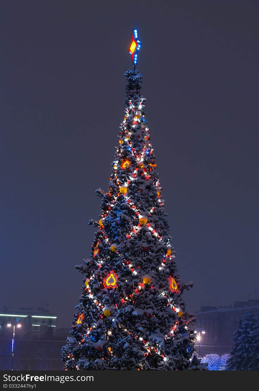 Christmas tree decorated with show on branches and garlands of night