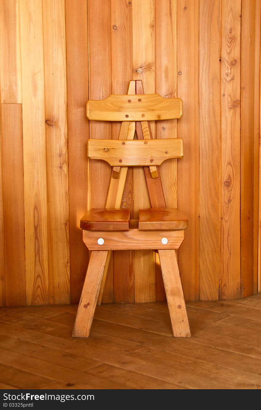 Wooden chair in front of a wood tiled wall