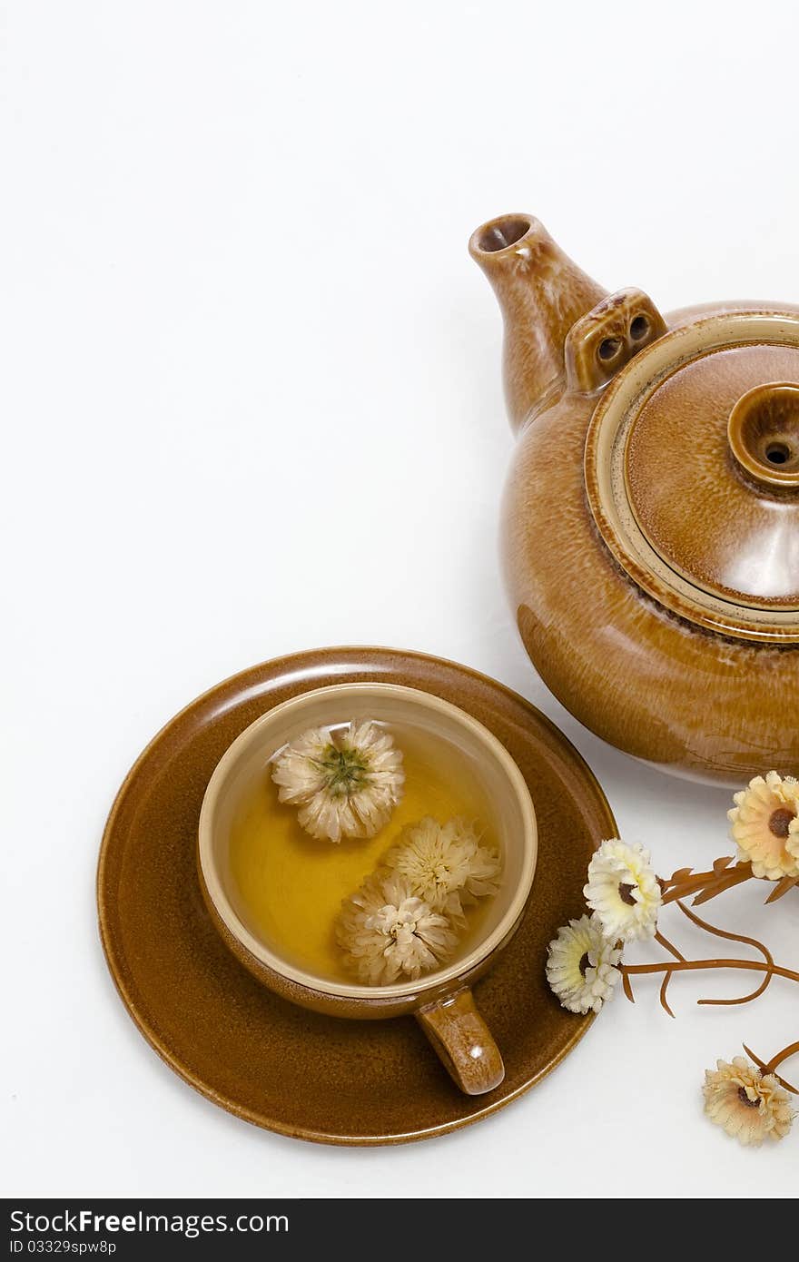 A cup of chrysanthemum tea and wood teapot mat, on a white background. A cup of chrysanthemum tea and wood teapot mat, on a white background