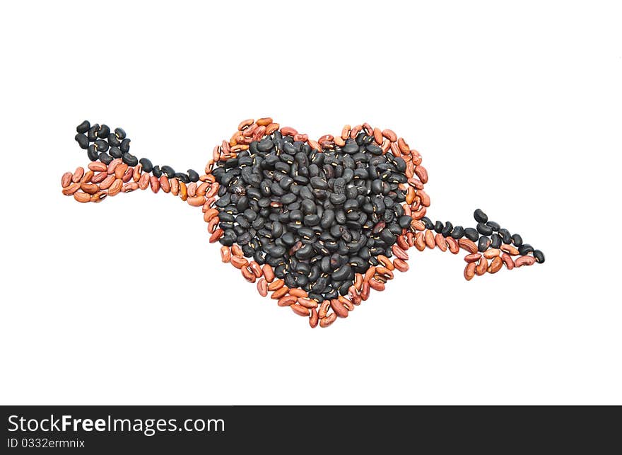 Black beans and yellow beans seed are arranged as heart shape with the arrow strike through isolated on white background. Black beans and yellow beans seed are arranged as heart shape with the arrow strike through isolated on white background.