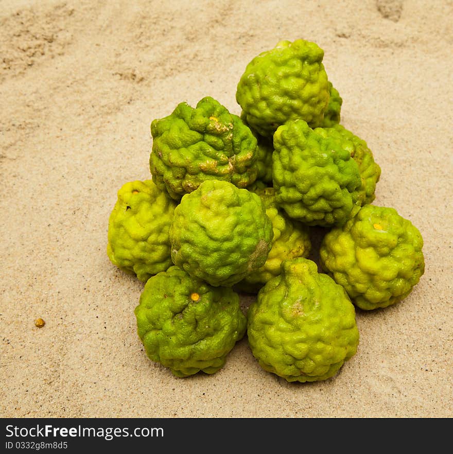 Green limes on sand are herps for spa beauty and food ingredient. Green limes on sand are herps for spa beauty and food ingredient.