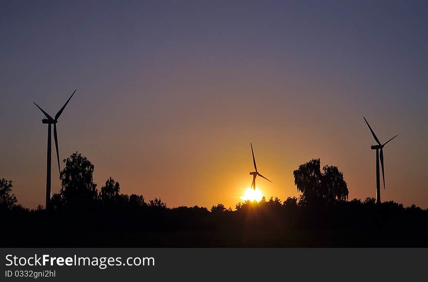 Wind turbine during sunset in summer time