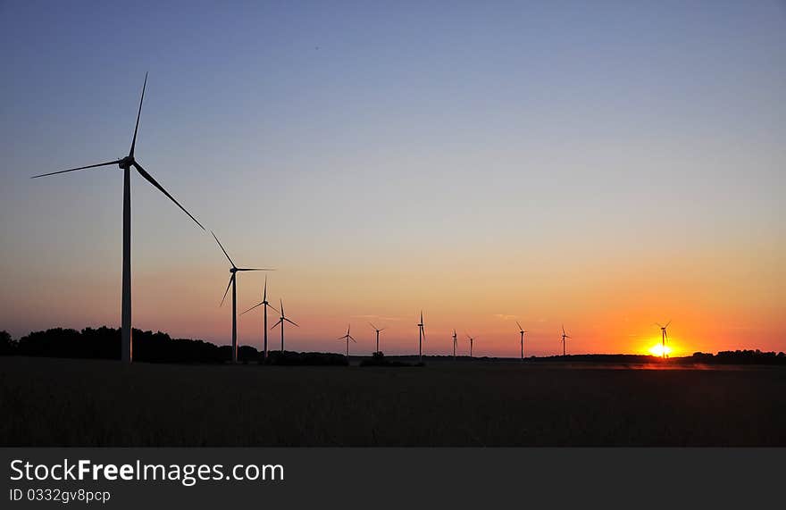 Wind turbine during sunset in summer time