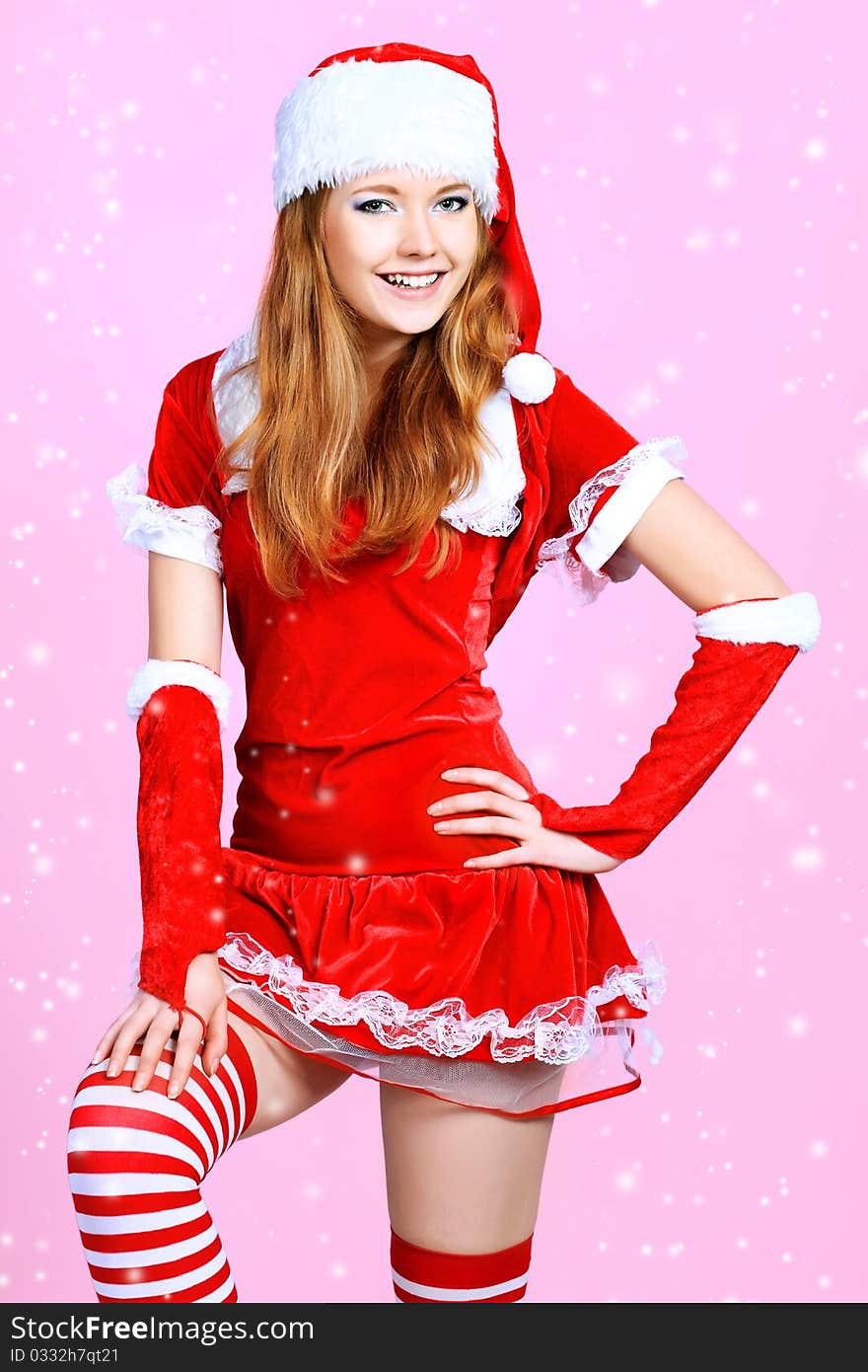 Beautiful young woman in Santa Claus clothes over pink background. Beautiful young woman in Santa Claus clothes over pink background.