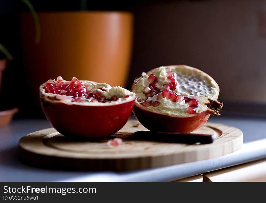 Two halves of pomegranate on the cutting board