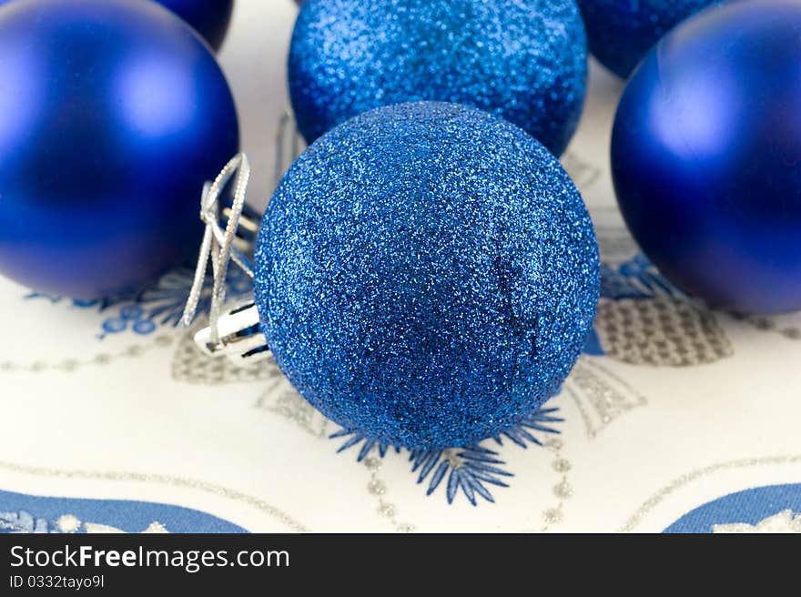 Christmas-tree decorations - blue glass balls are on a napkin closeup