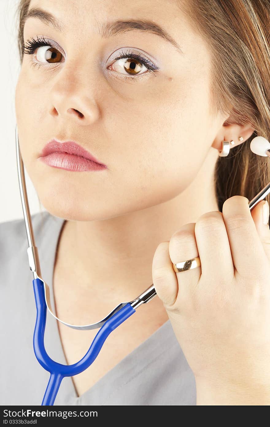 Young woman doctor or nurse holding a stethoscope wearing scrubs