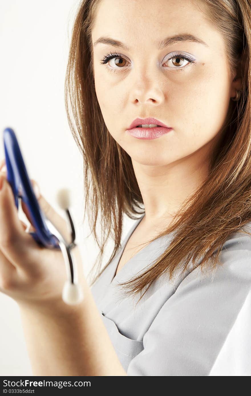 Young woman doctor or nurse holding a stethoscope wearing scrubs