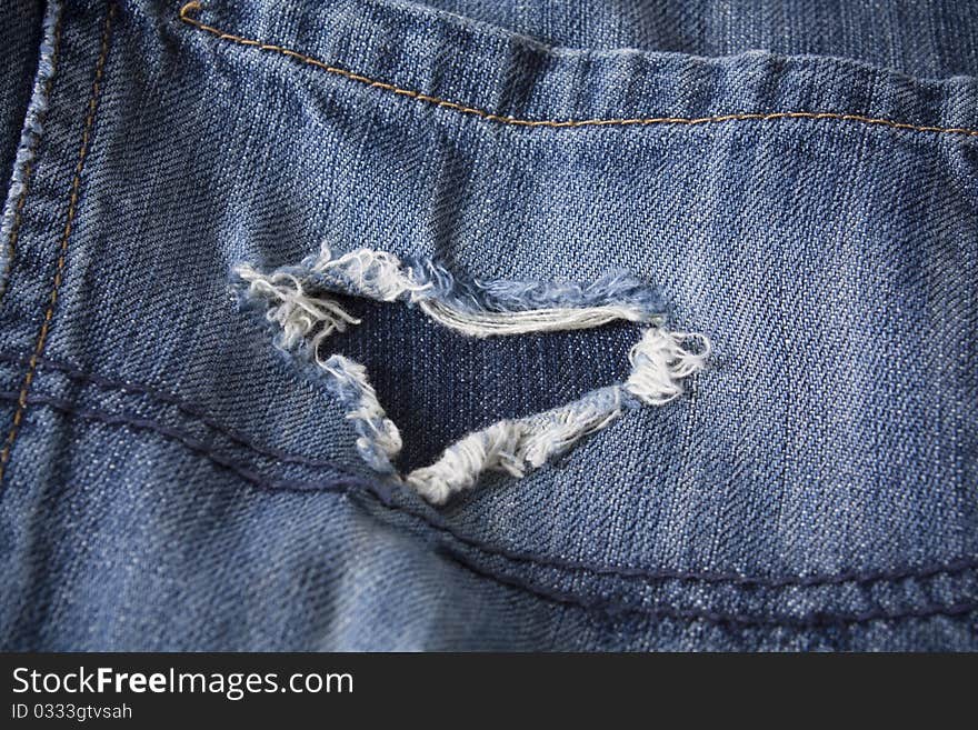 Pair of old jeans with frayed heart shaped rip. Pair of old jeans with frayed heart shaped rip