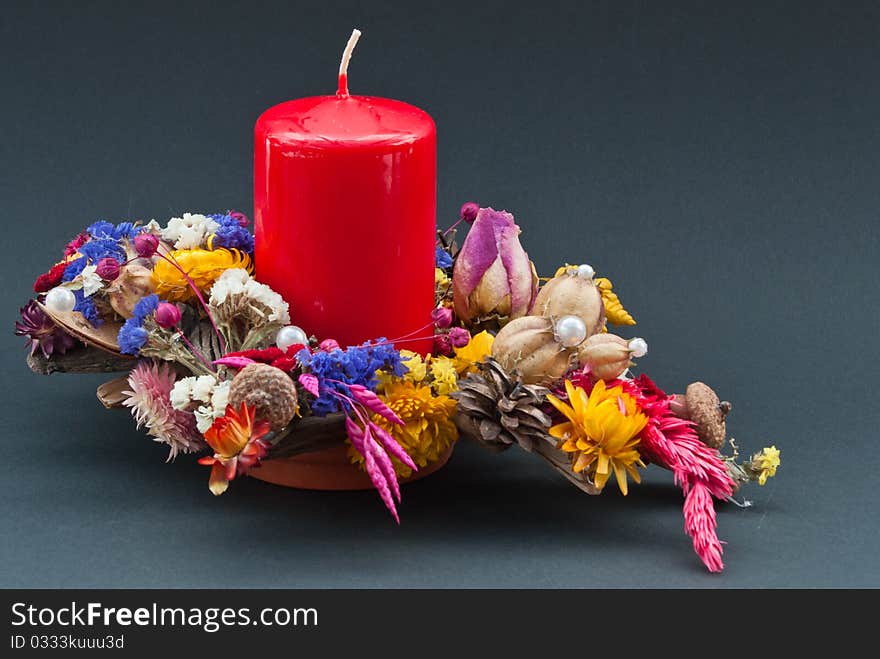 Decoration of dry flowers with a red candle on black background. Decoration of dry flowers with a red candle on black background.