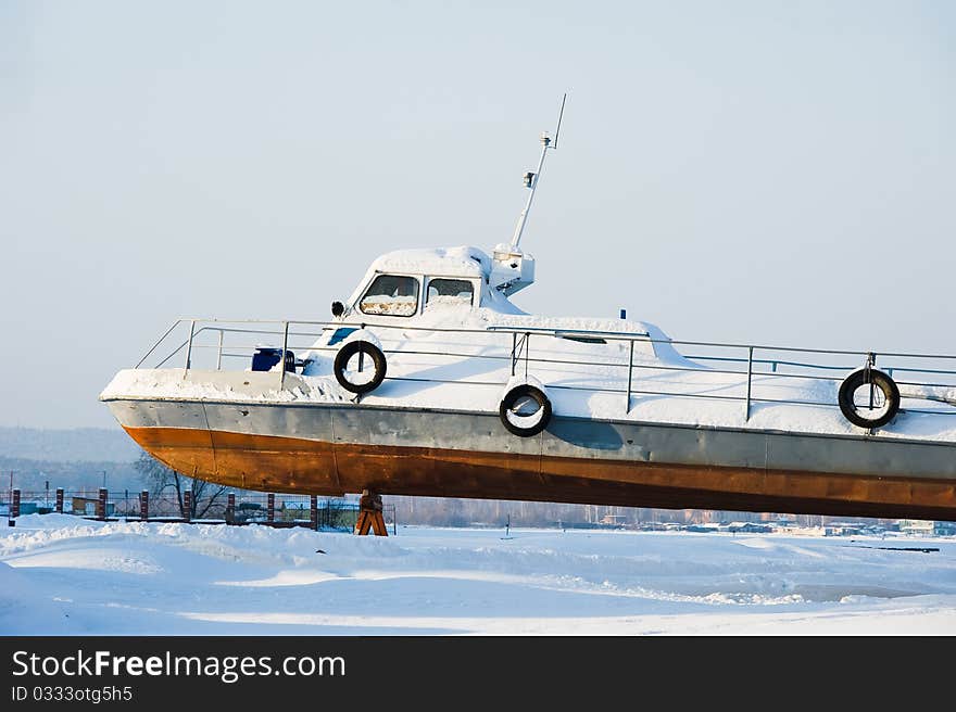 Snow-covered boat on winter mooring. Snow-covered boat on winter mooring