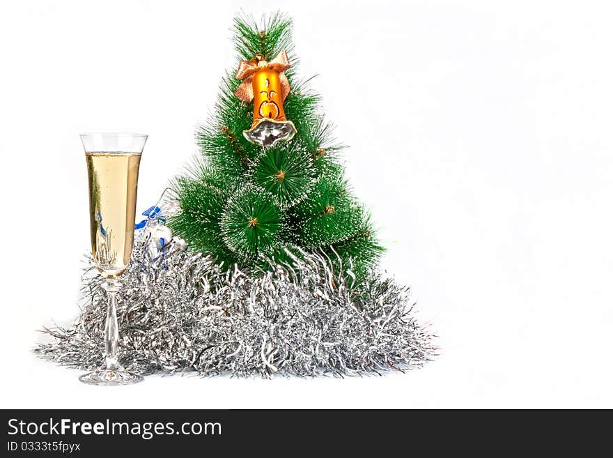 Christmas tree decorated with toys, tinsel and a glass of champagne with a symbol of New Year celebrations