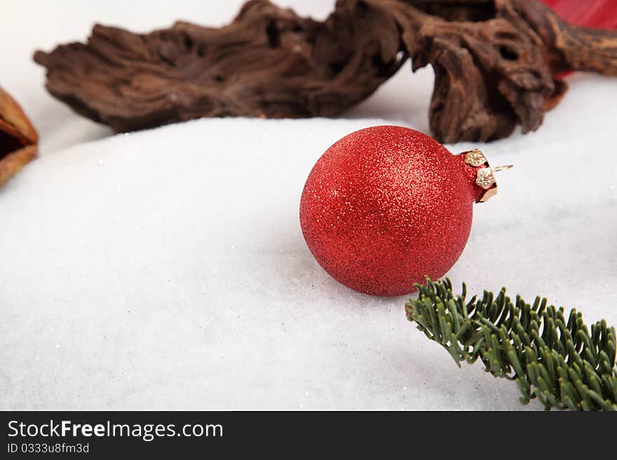 Christmas bauble with pine branch in the snow