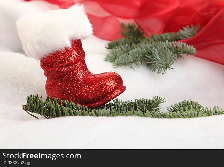 A Christmas boot in a winter landscape with branches. A Christmas boot in a winter landscape with branches