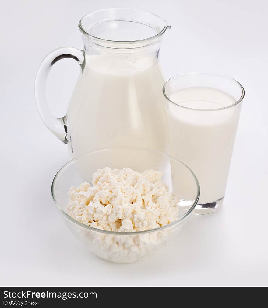 Jar and glass with milk and bowl with cottage cheese. Isolated on a white. Jar and glass with milk and bowl with cottage cheese. Isolated on a white.