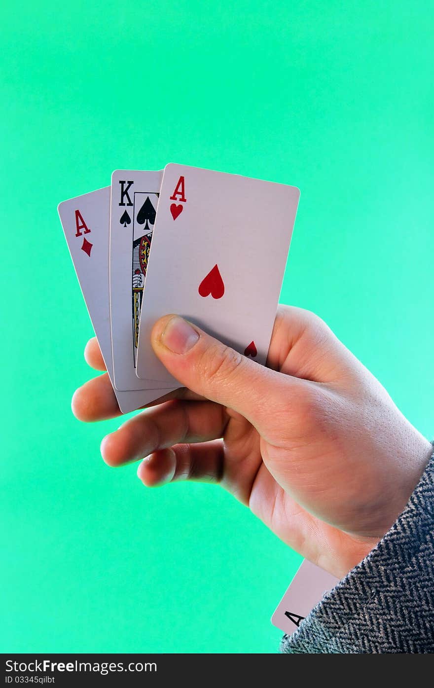 A man holding a playing card against a green background. A man holding a playing card against a green background